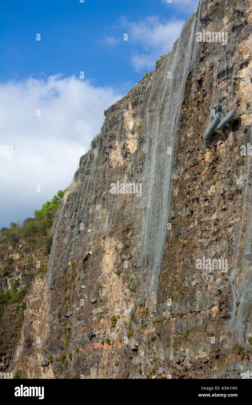 Defensive wire netting against rock fall dangers on coastal road in Réunion Stock Photo