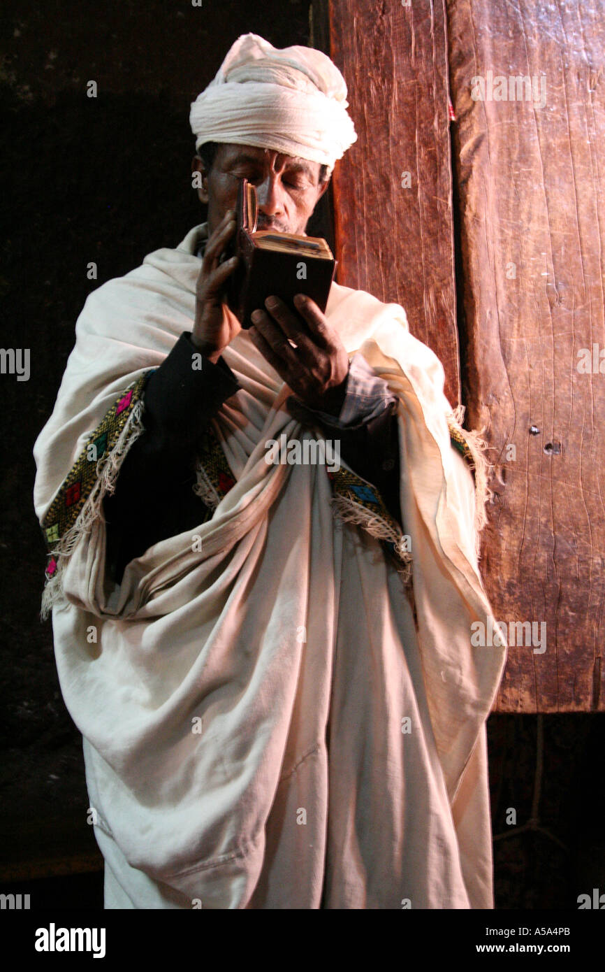 Lalibela, Ethiopia, Priest reading a bible inside one of the rock hewn churches Stock Photo