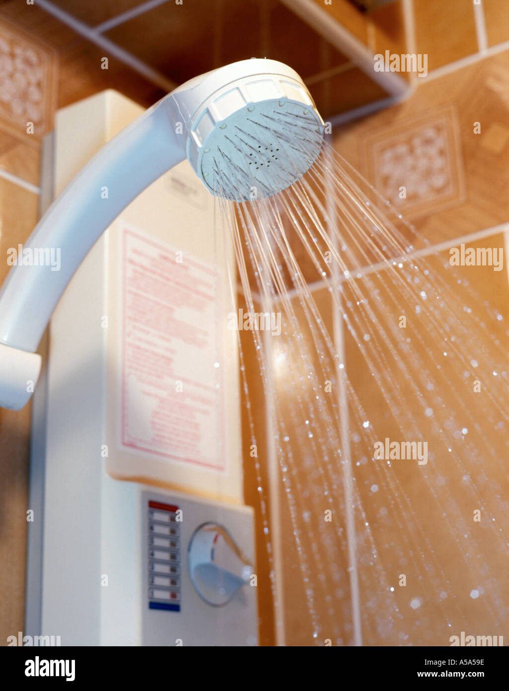 Domestic shower head with pump and water flow temperature control box beyond, UK Stock Photo
