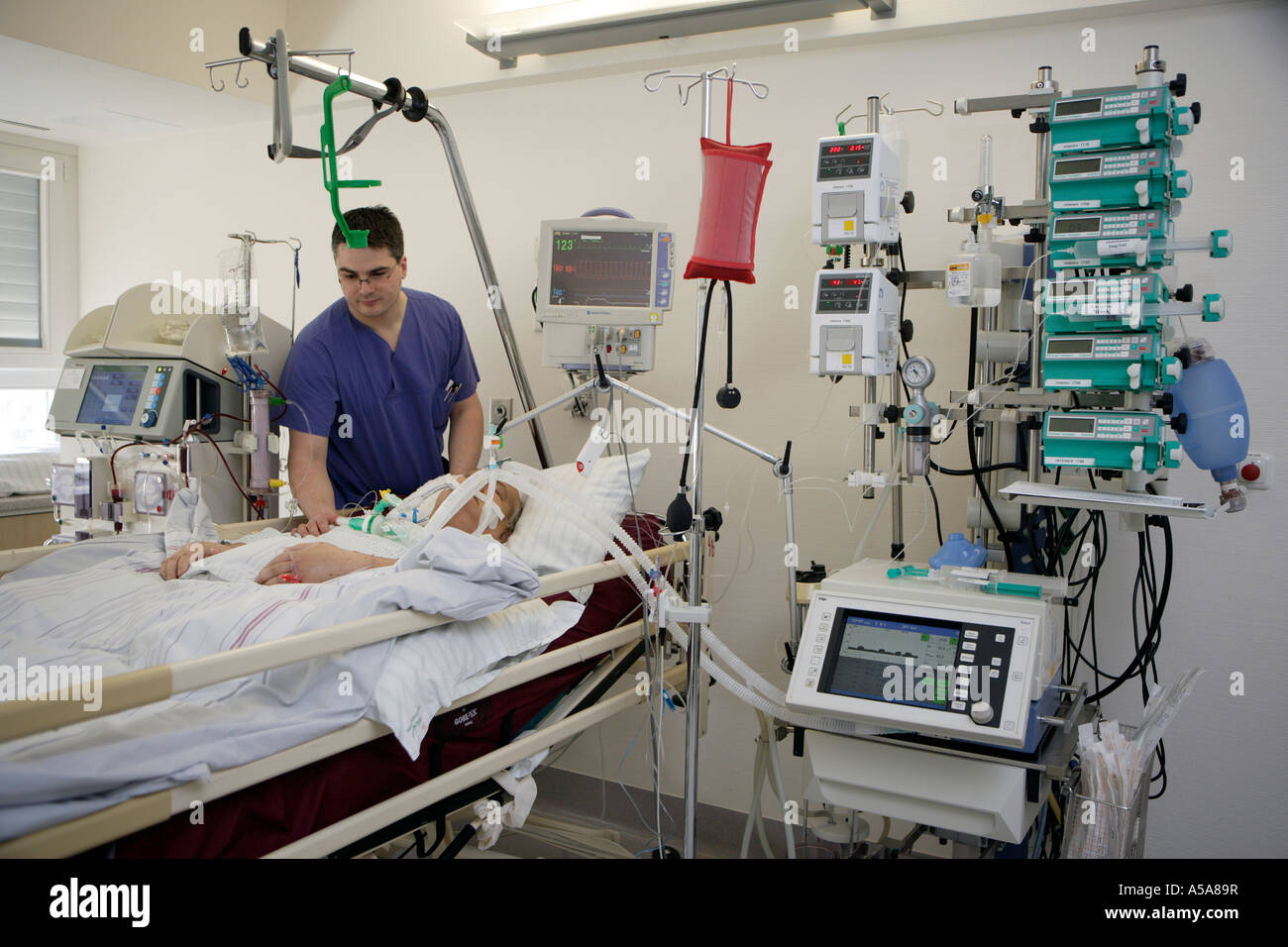 A MALE NURSES AND A PATIENT ON THE INTENSIVE CARE UNIT Stock Photo