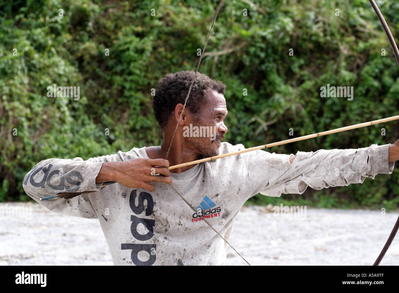 Aeta man draws back the string of his bow near Mount Pinatubo, Crater