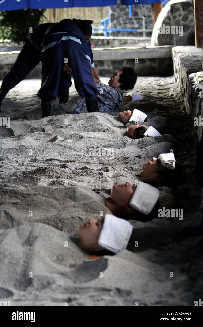 Korean People Burried in Hot Therapeutic Sand at a South Korean owned resort spa near Mount Pinatubo, Philippine Islands Stock Photo