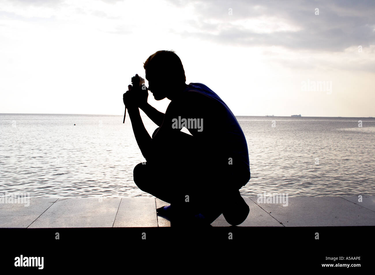 Manila, Philippine Islands, Manila Baywalk, students photograph the sunset over the bay, silhouette Stock Photo