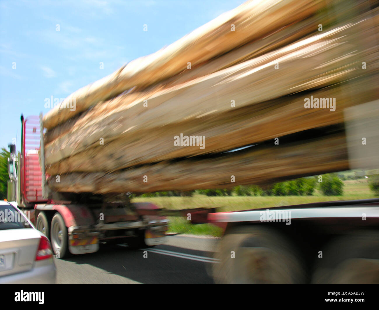 Timber truck passing car Stock Photo