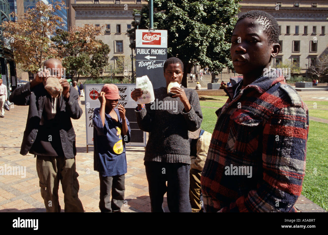 Young homeless boys sniffing glue on streets, Johannesburg, South Africa Stock Photo