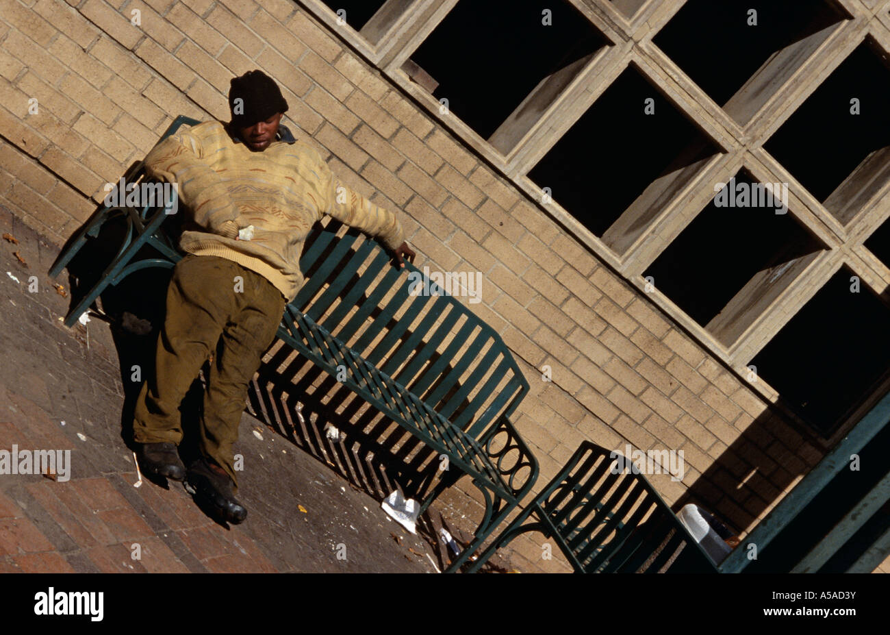 A man falling asleep on a bench in Johannesburg South Africa Stock Photo