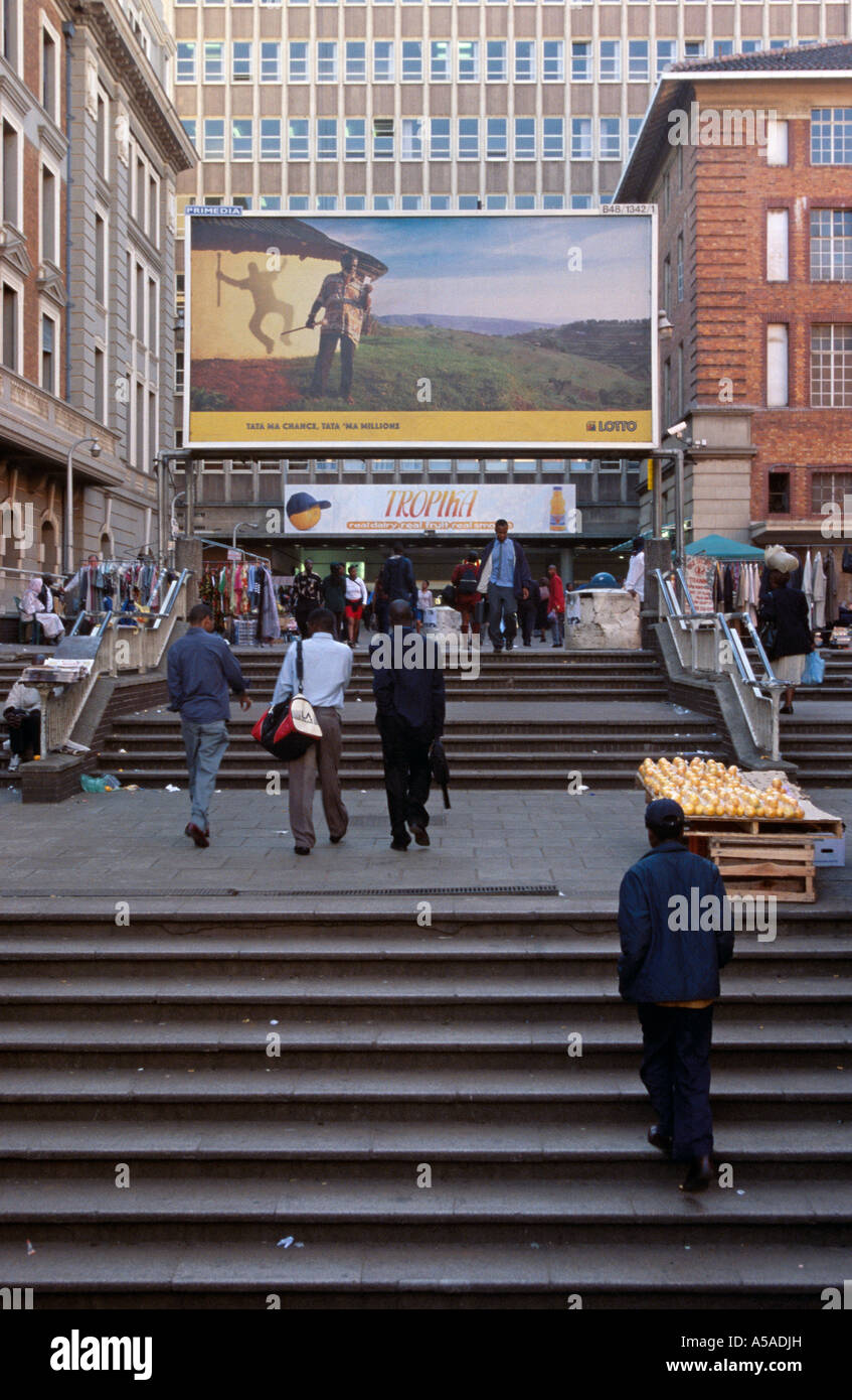 Pedestrians walking towards a huge Lotto billboard in Johannesburg