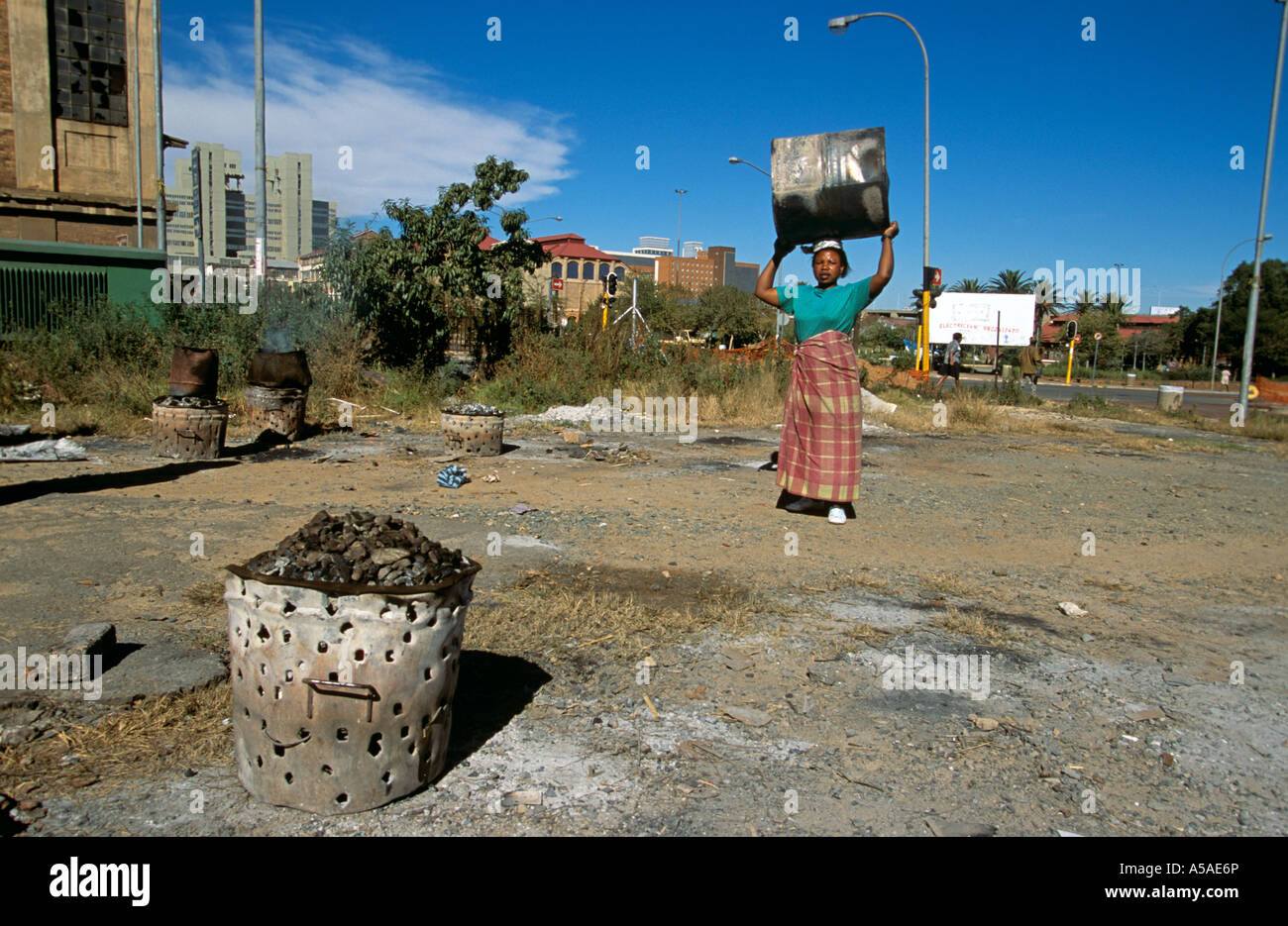 A South African woman preparing a fire to burn trash Stock Photo Alamy
