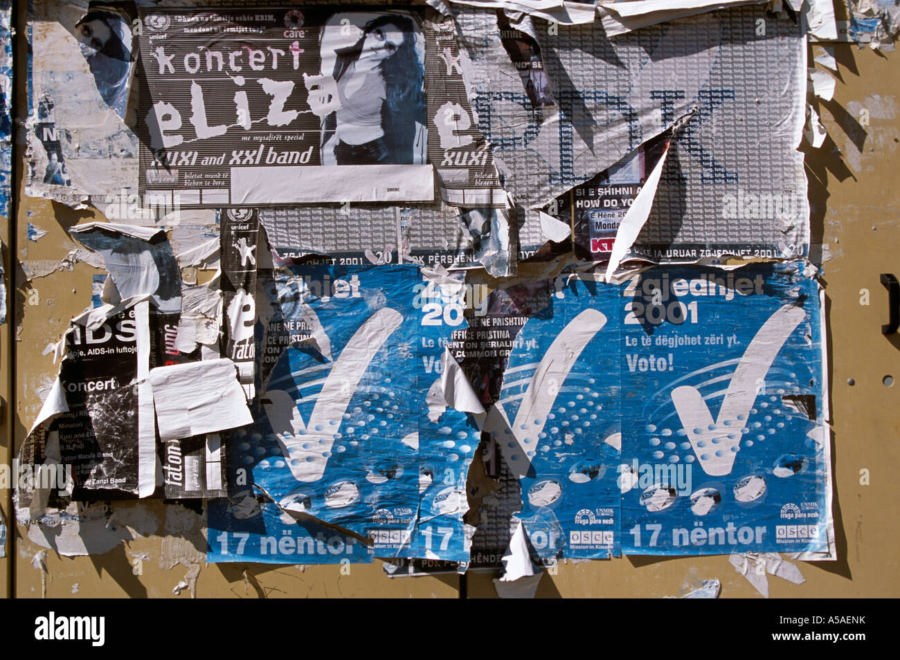 A wall full of torn paper posters in Kosovo Serbia and Montenegro Stock Photo