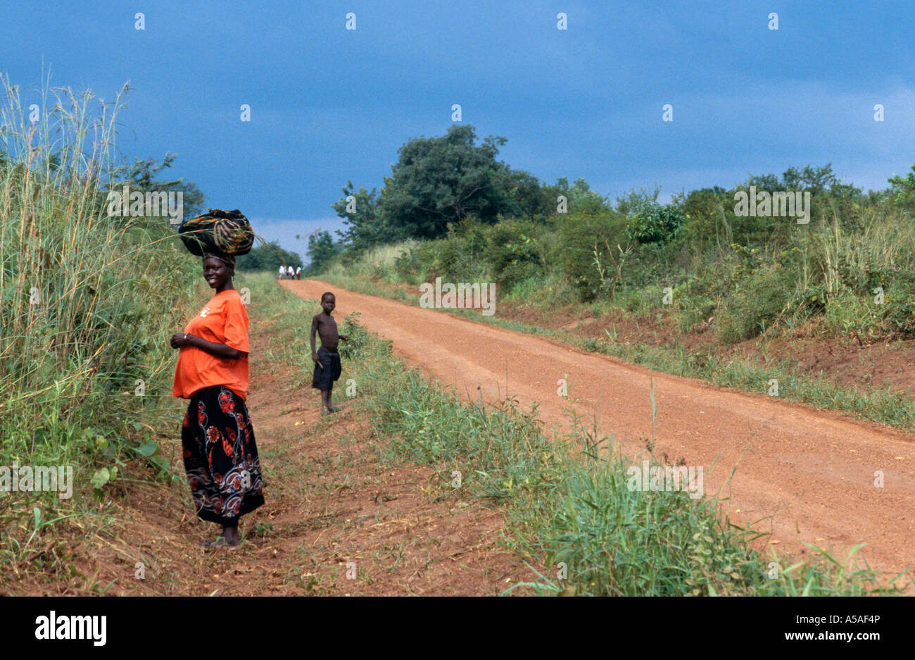 Mother and son resting on country road, Northern Uganda, East Africa Stock Photo