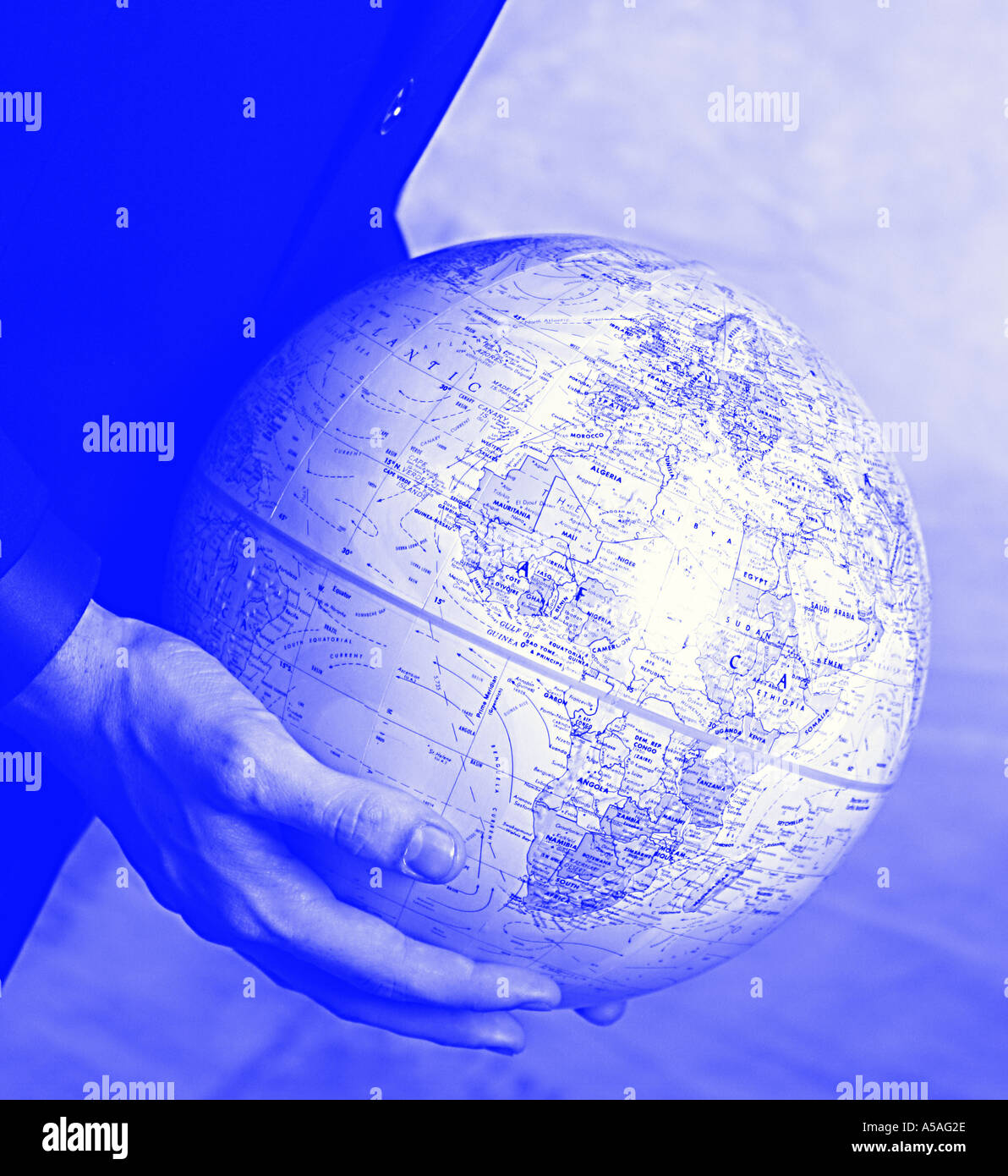 Hands holding globe in blue tint Stock Photo