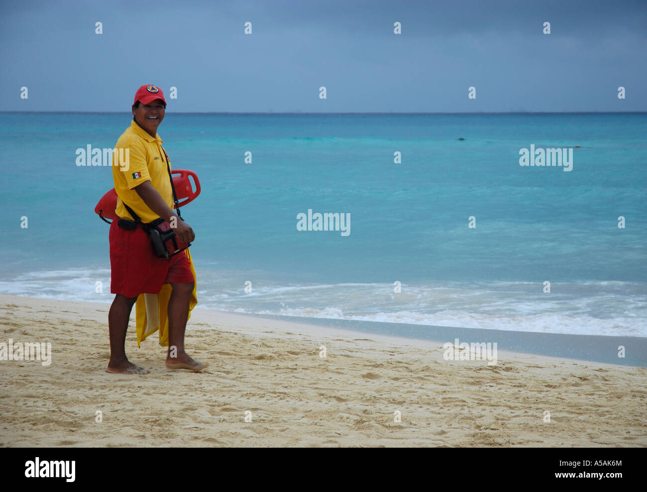 A life guard walks down the beach on a rainy day in Playa del Carmen