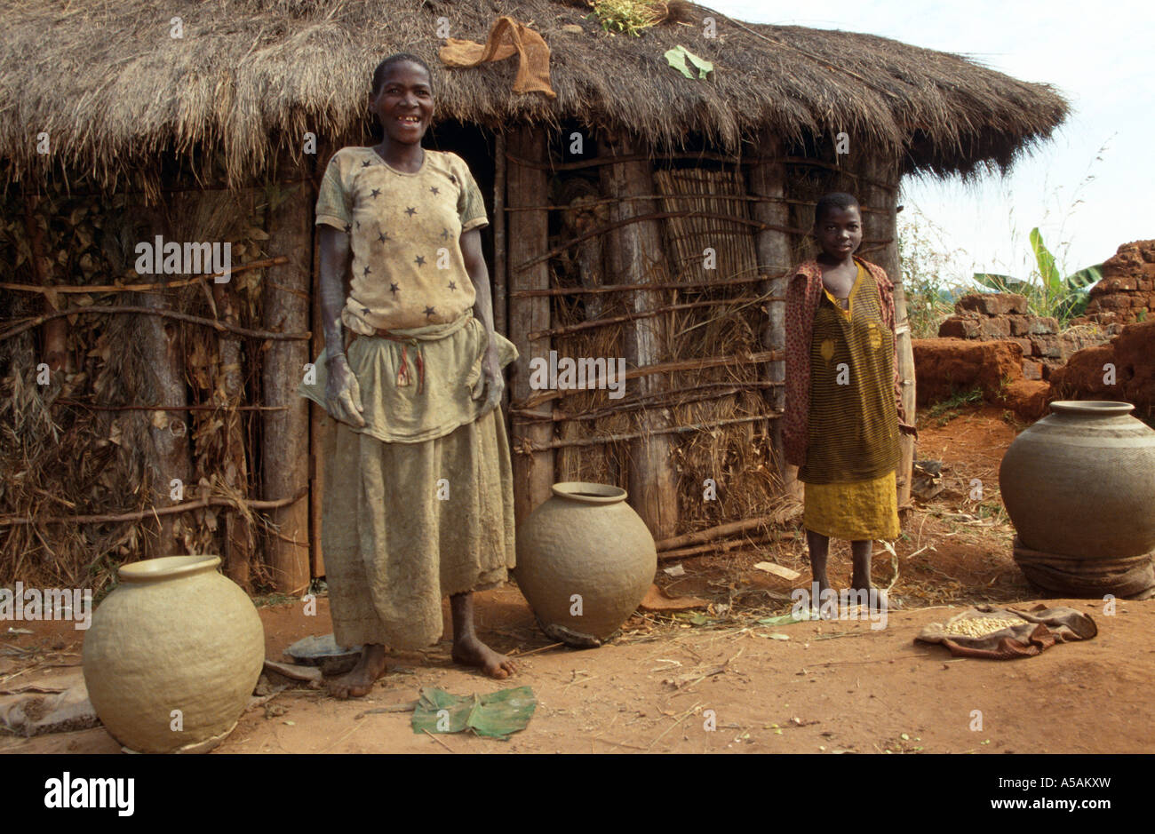 African women and son smiling in front of hut, Western Uganda, Africa Stock Photo