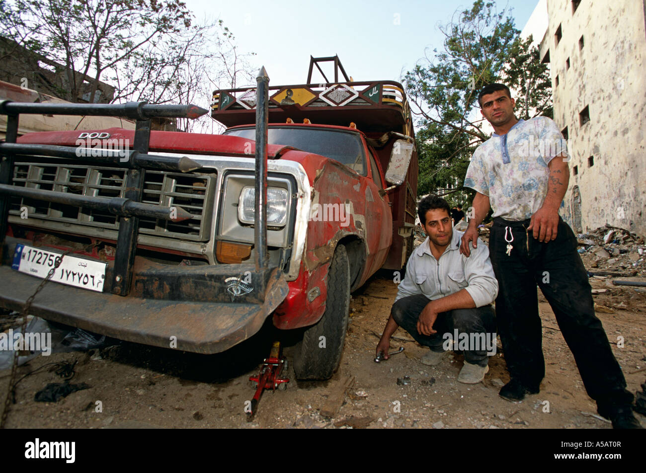 Men standing beside a damaged car Beirut Stock Photo