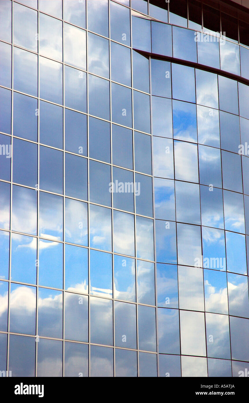 Sky and clouds reflected in modern glass facade of office building ...