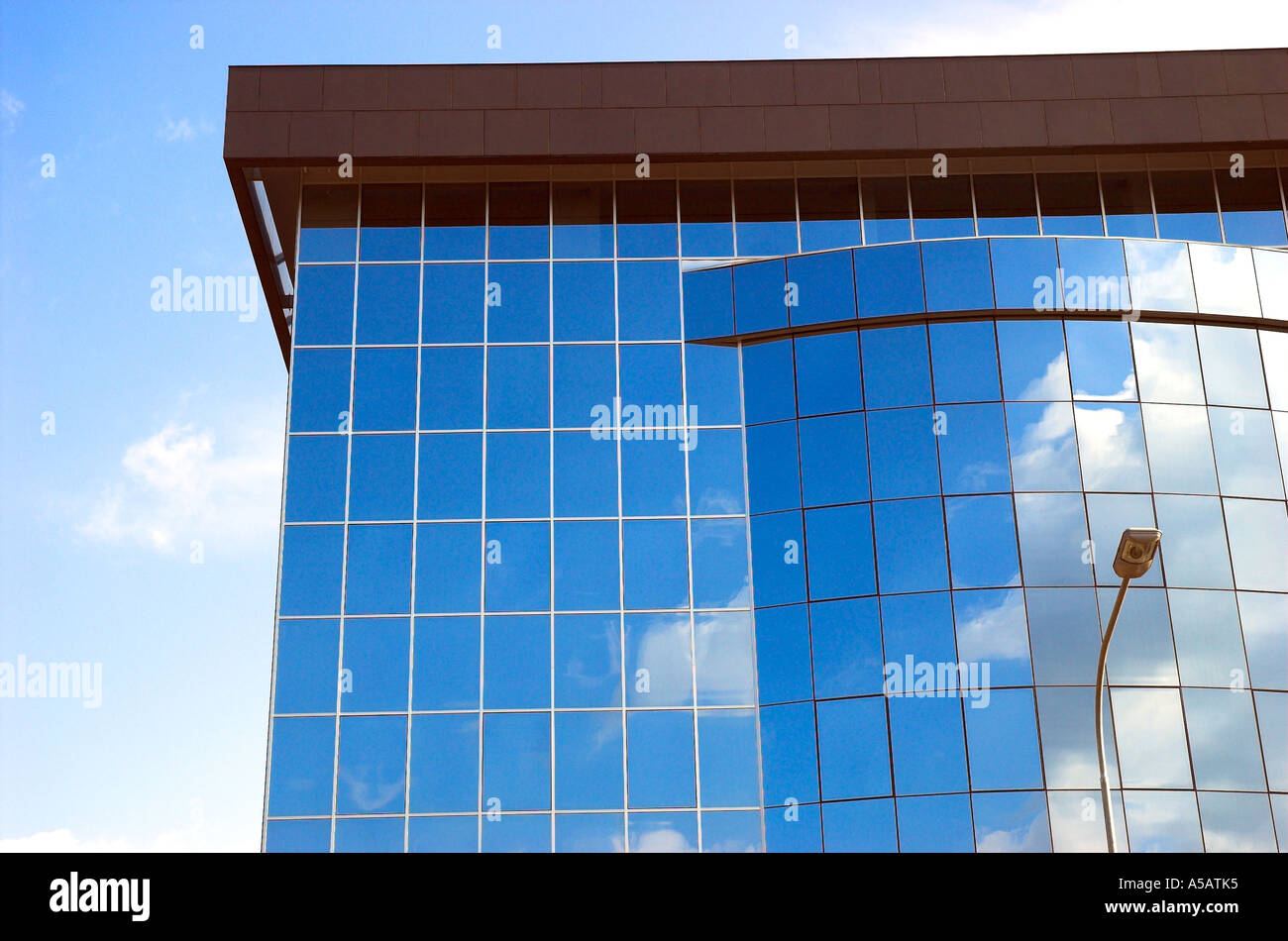 Sky and clouds reflected in modern glass facade of office building ...