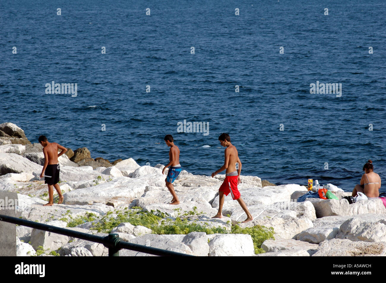 Swimmers on the rocks Naples Stock Photo - Alamy