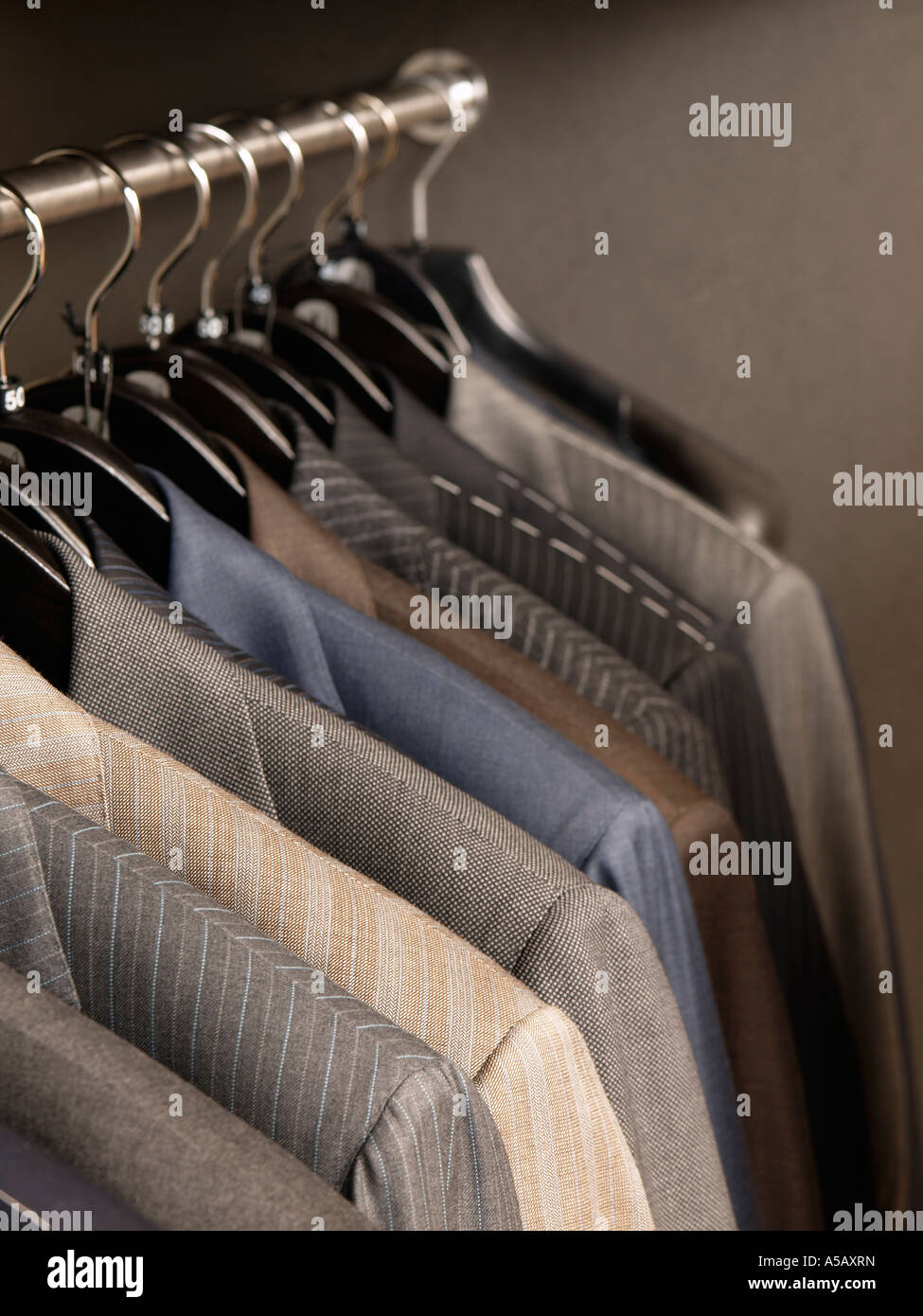 Mens business wardrobe jackets blazers hanging on a rail in a shop grey gray stylish fashion Stock Photo