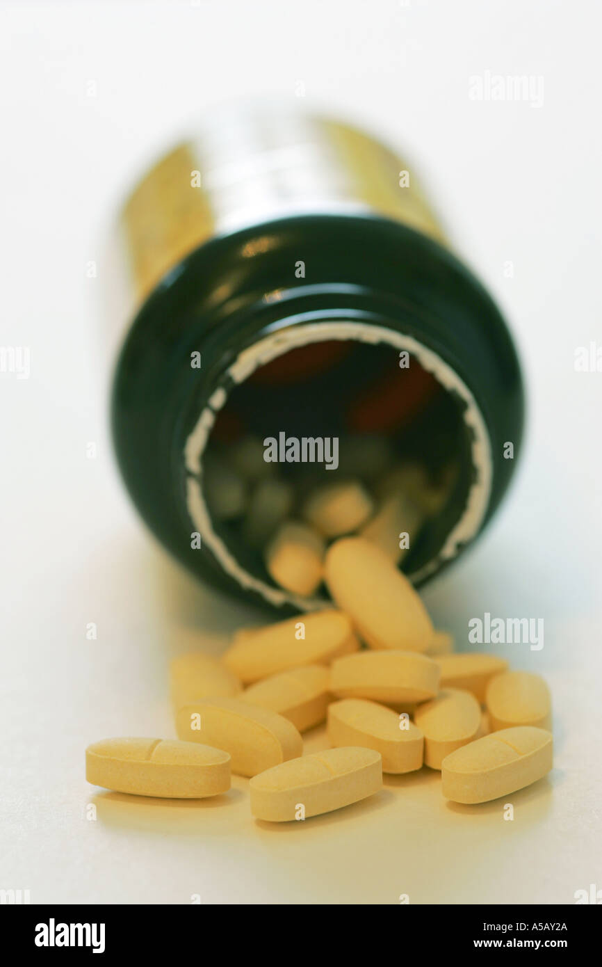 Multi vitamin and mineral pills tablets spill from a generic medicine