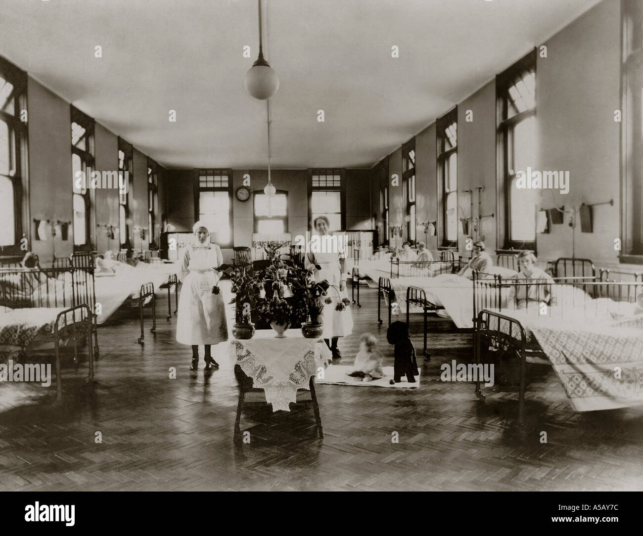 Mother and baby ward with nurses in attendance hospital in the 1920s,  group groups occupational portrait portraits., U.K. Stock Photo