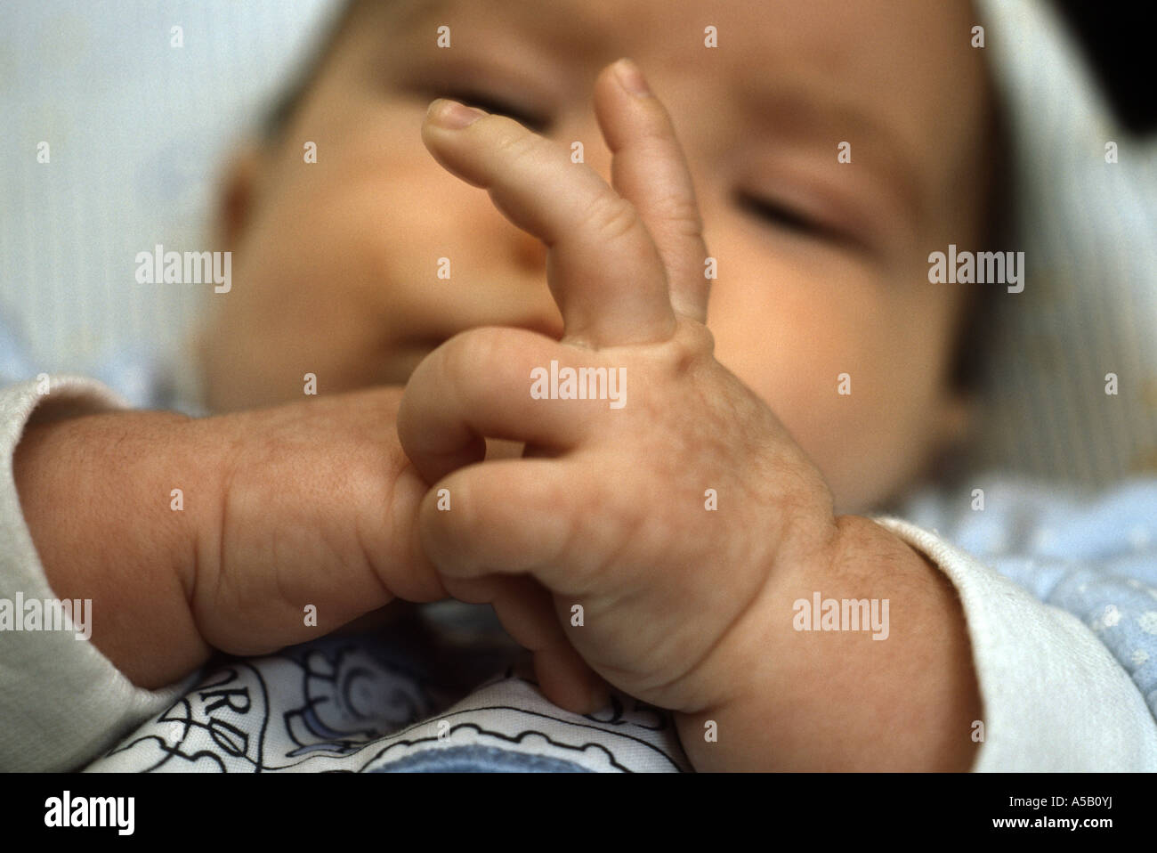 Nine week old baby boy discovering his fingers Stock Photo