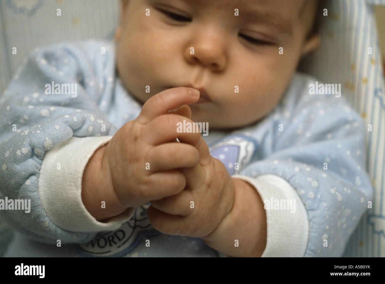 Nine week old baby boy discovering his fingers Stock Photo