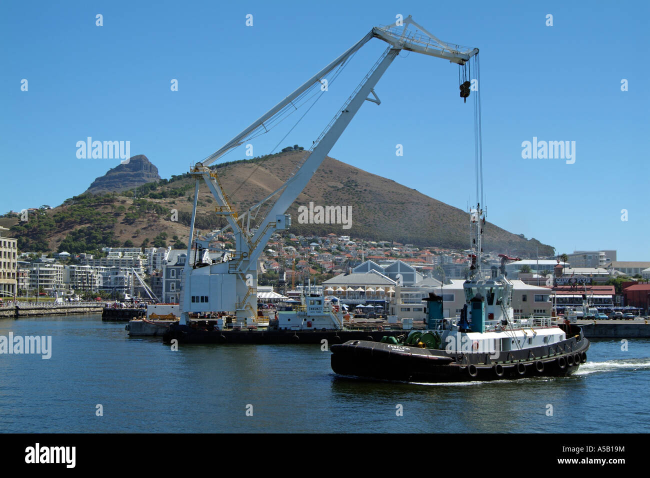 Port of Cape Town South Africa sitting below Signal Hill Floating crane Inkunzi and the seagoing tug Enseleni leaving the Alfred Stock Photo