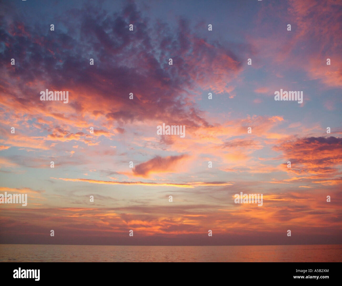 Vibrant sunset sky over ocean Stock Photo - Alamy