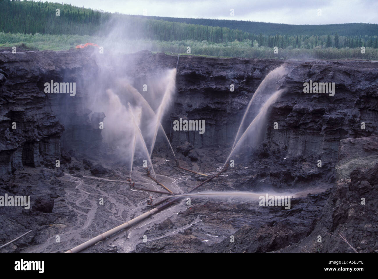 High pressure waterhoses flush dirt from permafrost ground goldmining, Livengood, Alaska Stock Photo