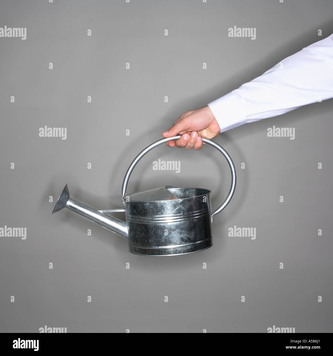 Watering can in outstretched arm Stock Photo