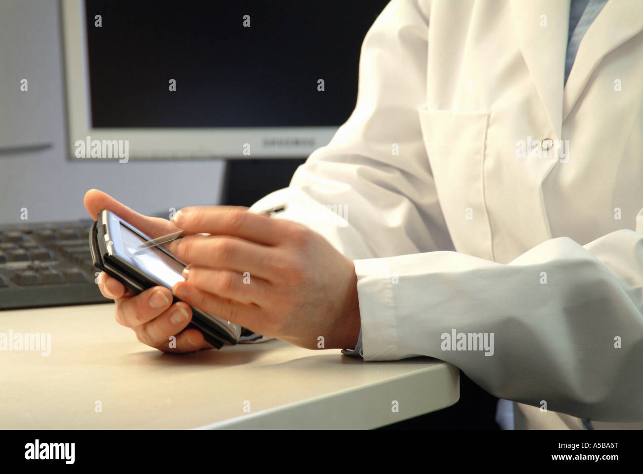 Healthcare worker using medical mobile PDA in doctor's office Stock