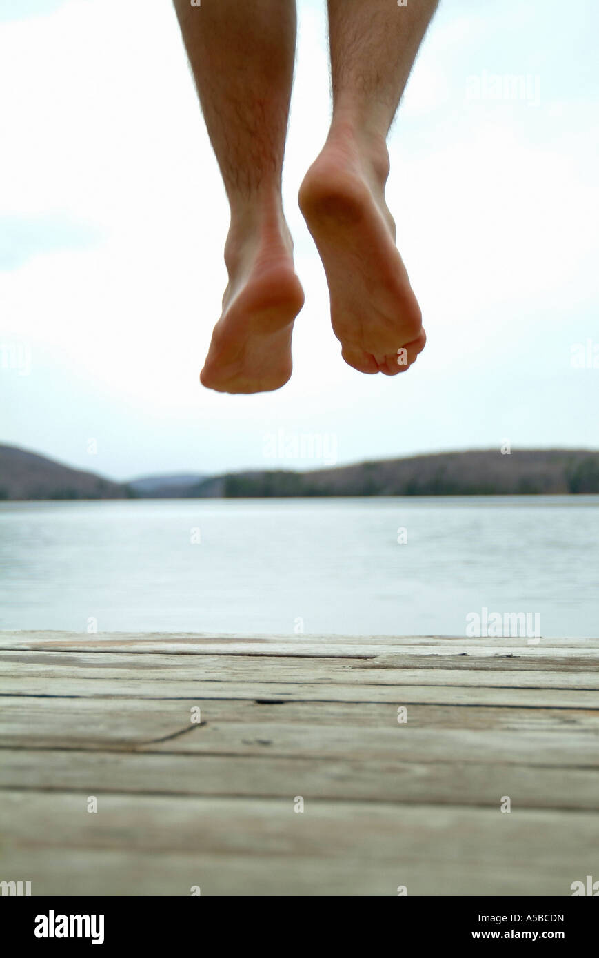 Feet jumping of cottage dock into water Stock Photo Alamy