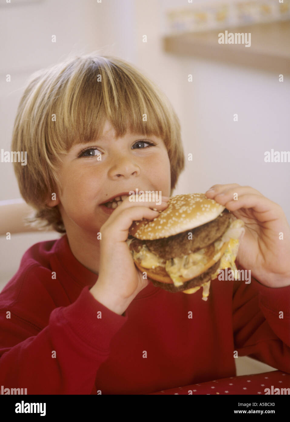 Boy eating a burger happy Stock Photo Alamy