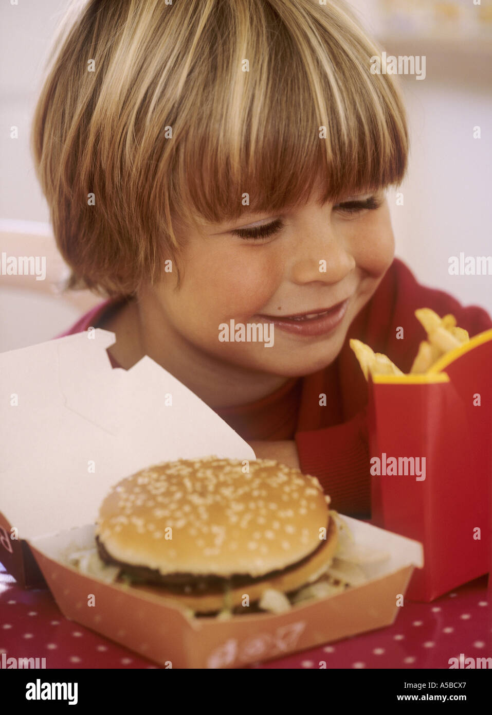 Boy with box of chips and a burger - happy Stock Photo