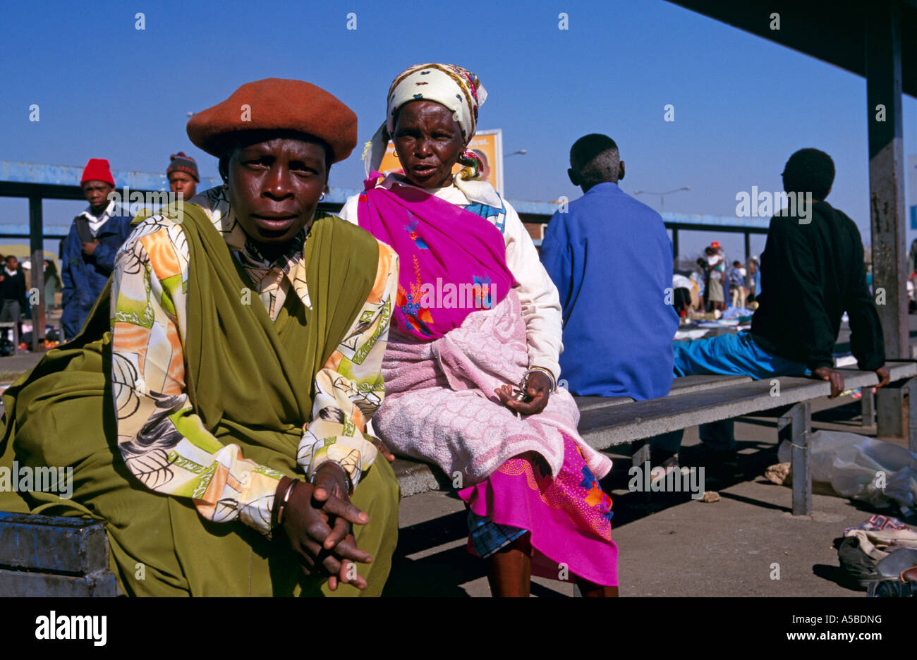 Villagers waiting on bench, Soweto, South Africa Stock Photo