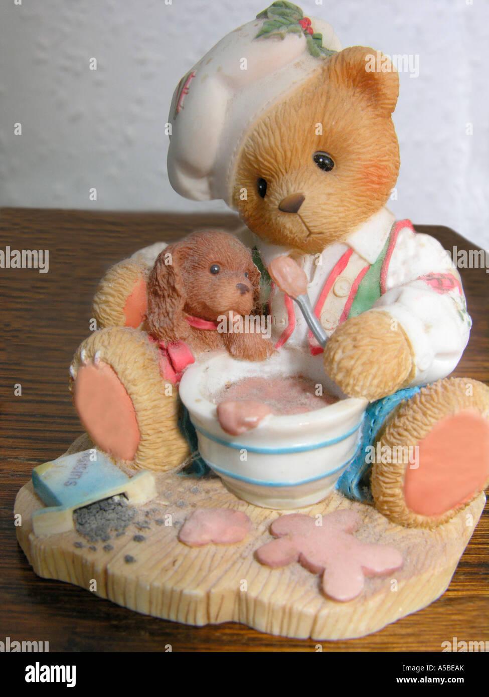 cute teddy bear and dog figurines with a Christmas theme mixing up a cake Stock Photo
