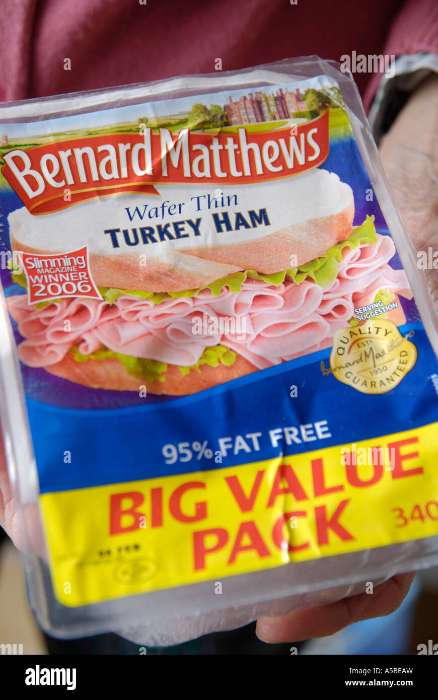 elderly woman holding a container of Bernard Matthews turkey ham Stock