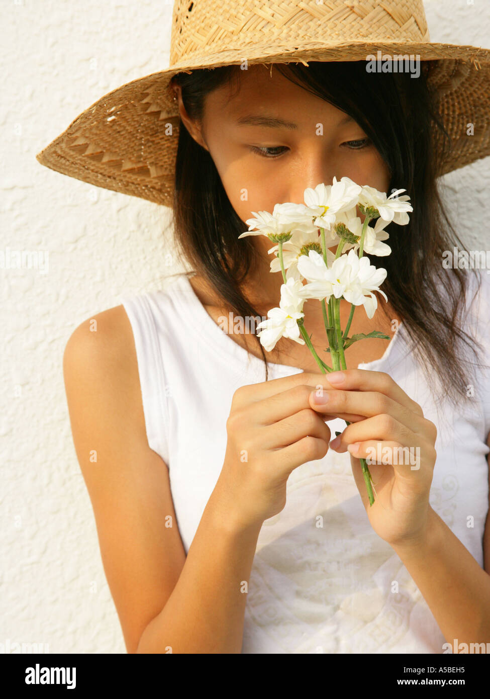 Teenage girl smelling flowers Stock Photo - Alamy