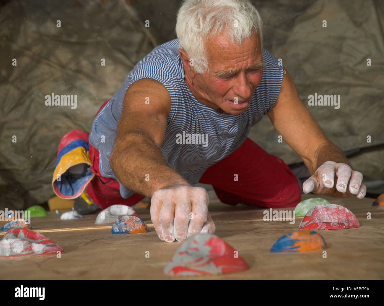 elderly man climbing on an artificial climbing wall elevated view of