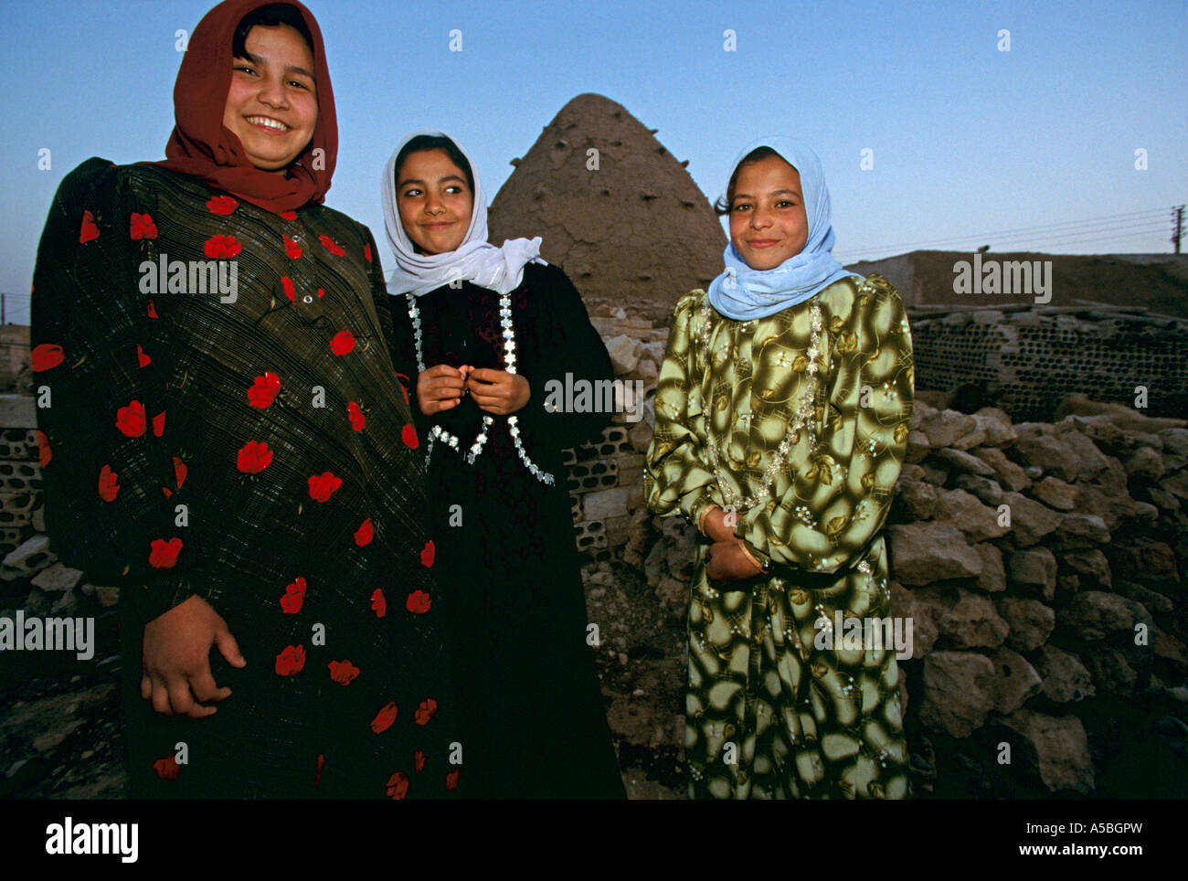 Three Syrian women in front of beehive house, Aleppo, Syria Stock Photo