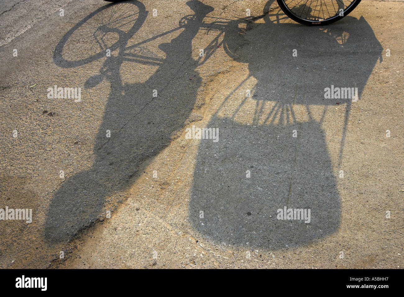 Shadow on road of driver and bicycle rickshaw Kanchanaburi Thailand Stock Photo