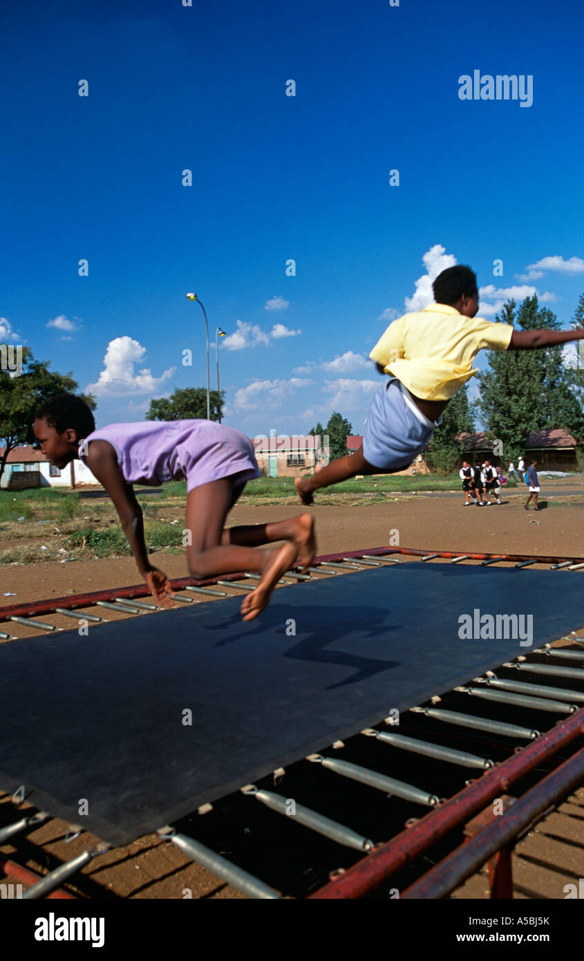 Schoolchildren playing on trampoline, Soweto, South Africa Stock Photo