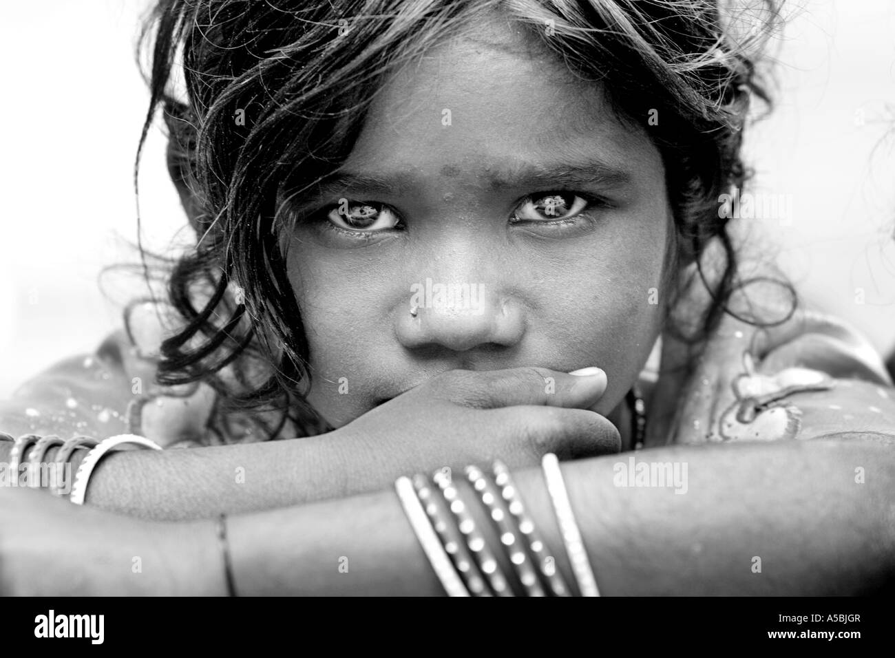 Monochrome shot of little Indian street girl staring intensely into camera Stock Photo