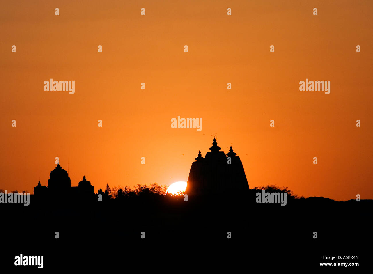 Silhouette profile of Indian ashram building architecture and sunset in the south India town of Puttaparthi Stock Photo