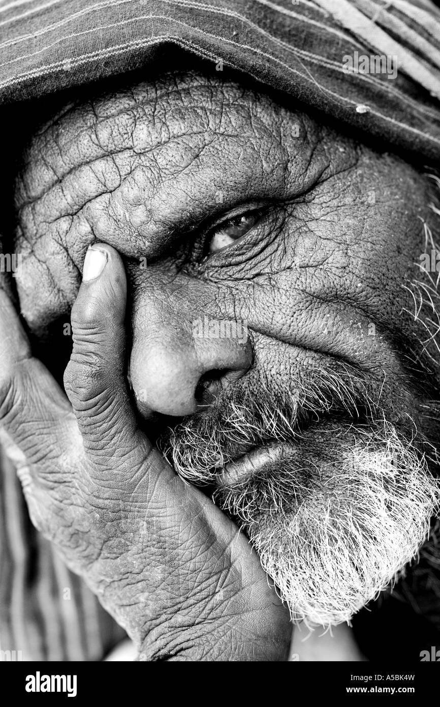 Old Indian man with his head in his hands. Andhra Pradesh, India. Black and White Stock Photo