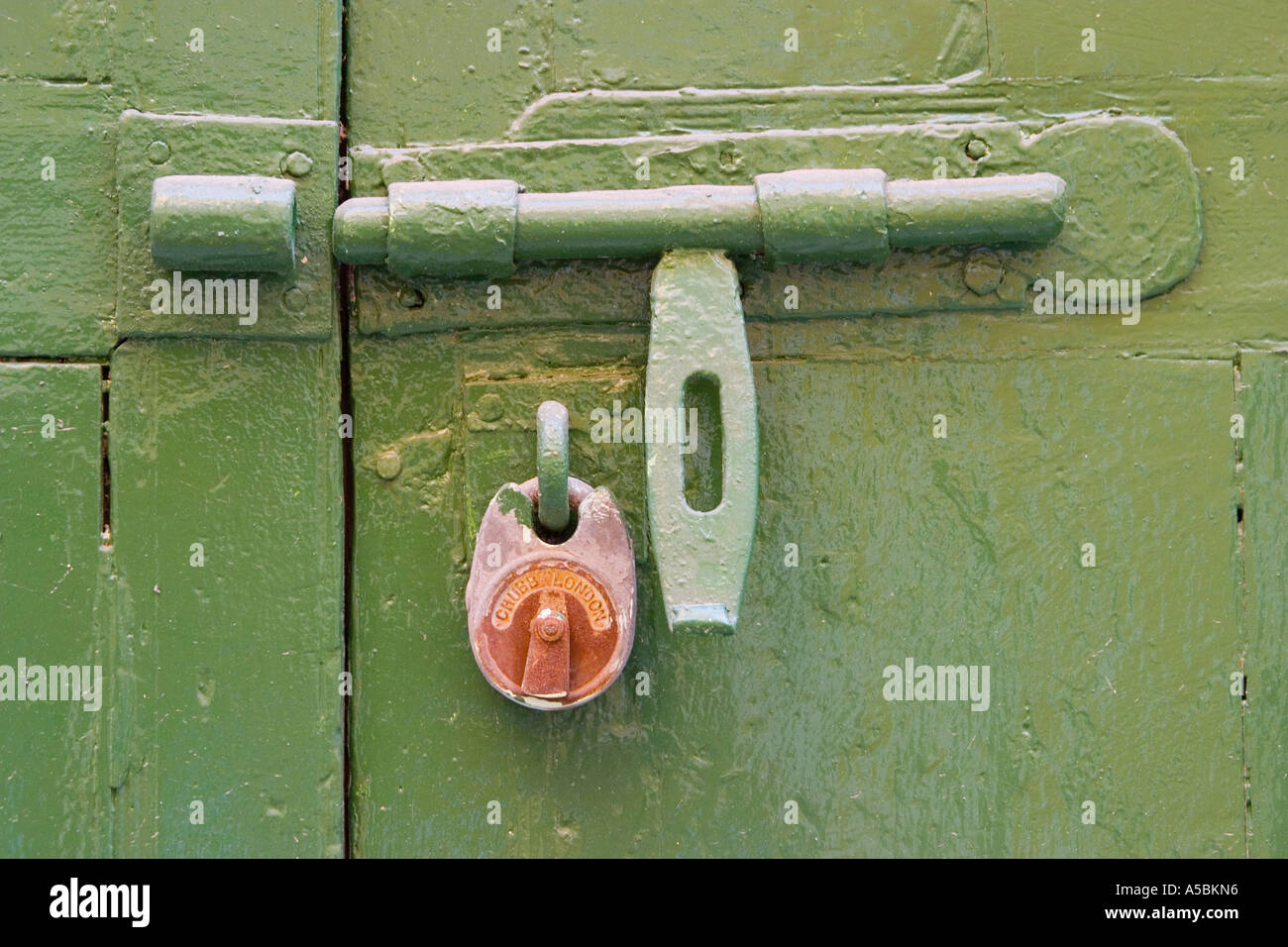 Open bolt and closed lock on old double door Stock Photo