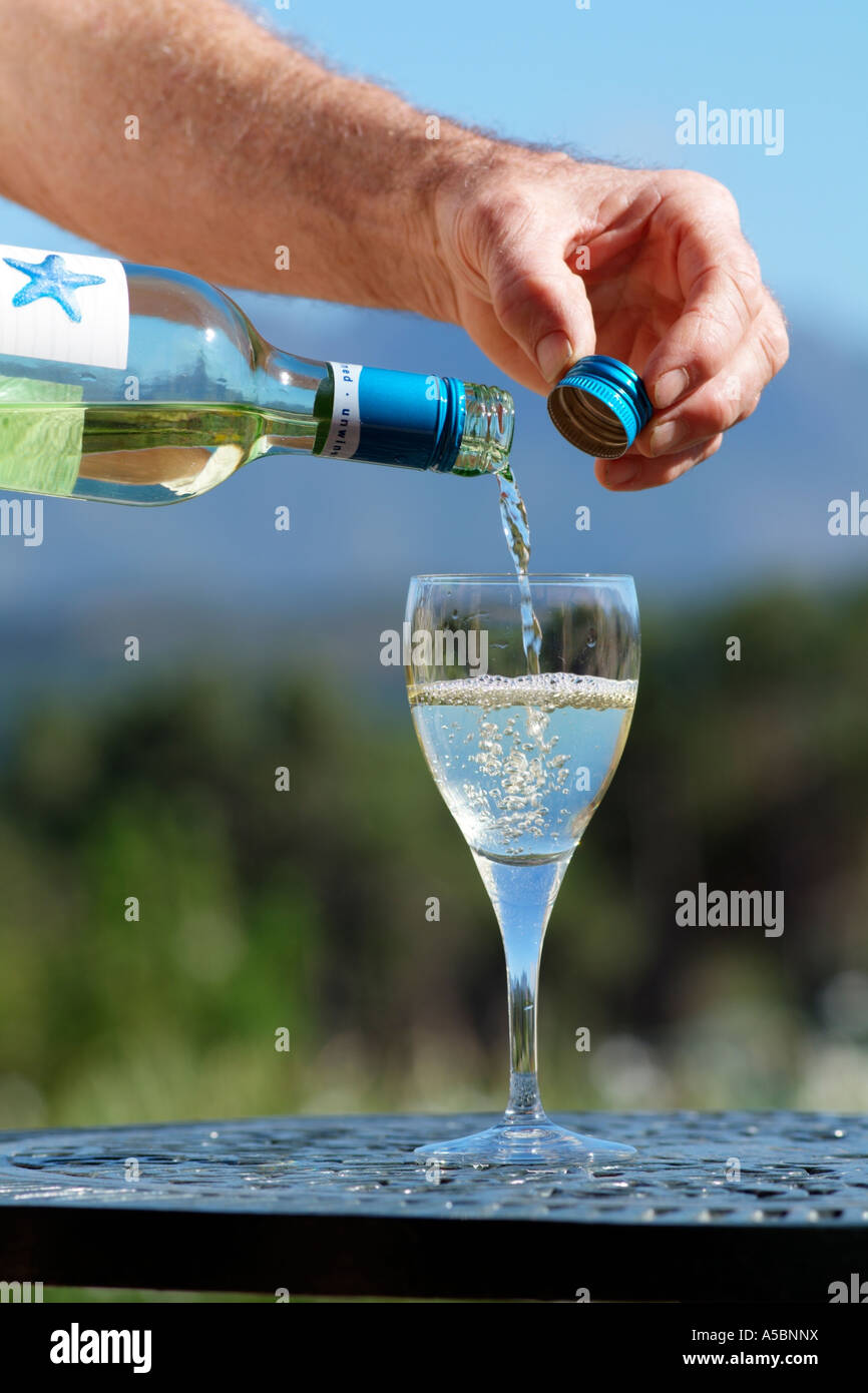 Screw cap on South African wine bottle White wine being poured into a wine glass Stock Photo