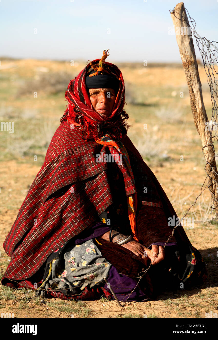 Horizontal portrait of berber woman in traditional dress sitting outdoors mending her sheep pen fence Tunisia North Africa Stock Photo Alamy