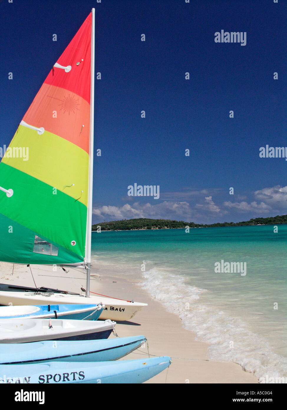 Brightly coloured dinghy and watersports equipment sail Chaweng Beach Ko Samui island Thailand