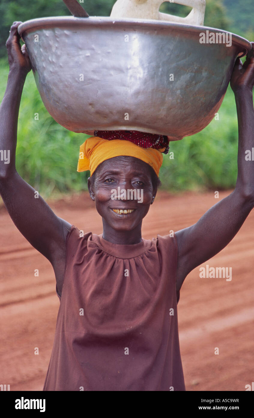 Woman carrying a bowl, on her way to work, picking maize, Volta Region, Ghana,  West Africa Stock Photo